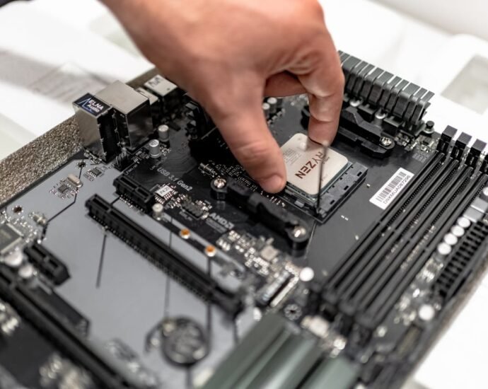 Hand installing or removing a CPU from a motherboard, showing the pins of the CPU.